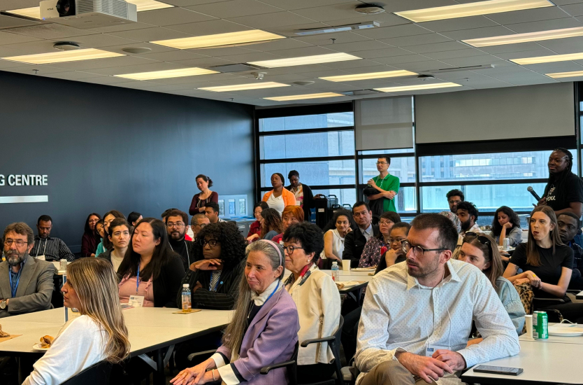 Group of people sitting at tables watching presentation