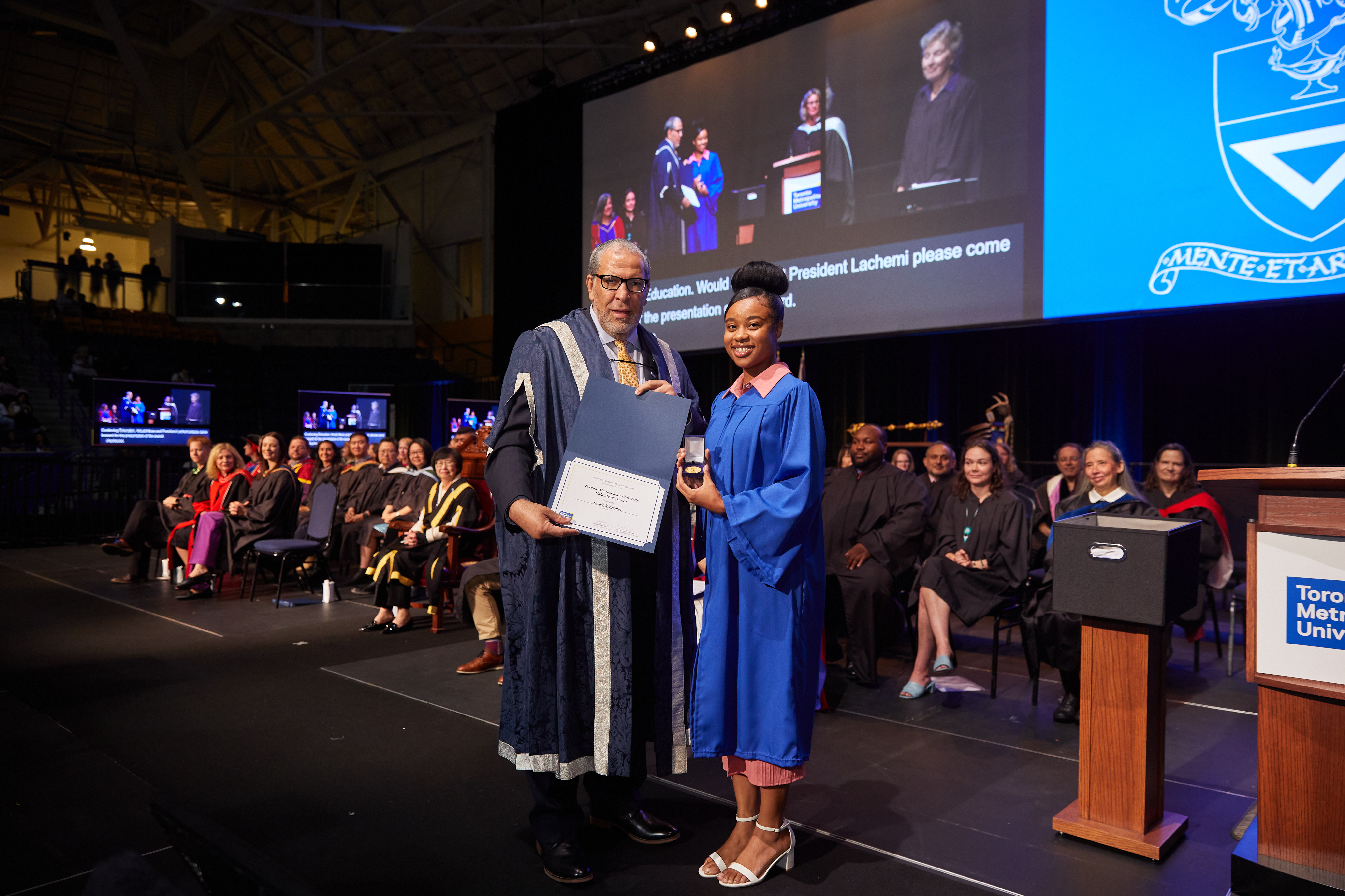 Renée Benjamin accepting the Gold Medal Award at Convocation from TMU President and Vice Chancellor, Mohammed Lachemi 
