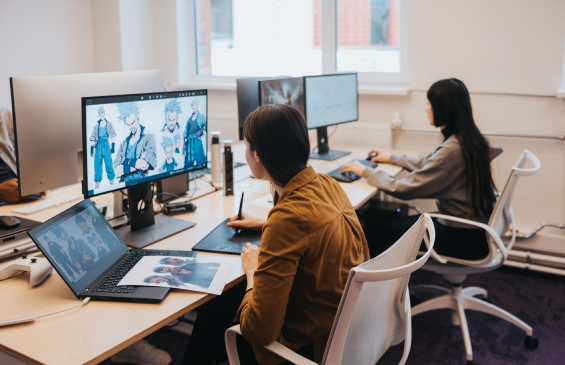 A female gaming developer focuses intently, sketching new characters for the game that's being developed in their gaming studio
