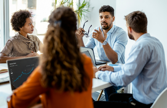  Group of young professionals discussing business while sitting in an office 