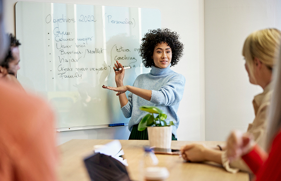Project manager using whiteboard to communicate plans to colleagues