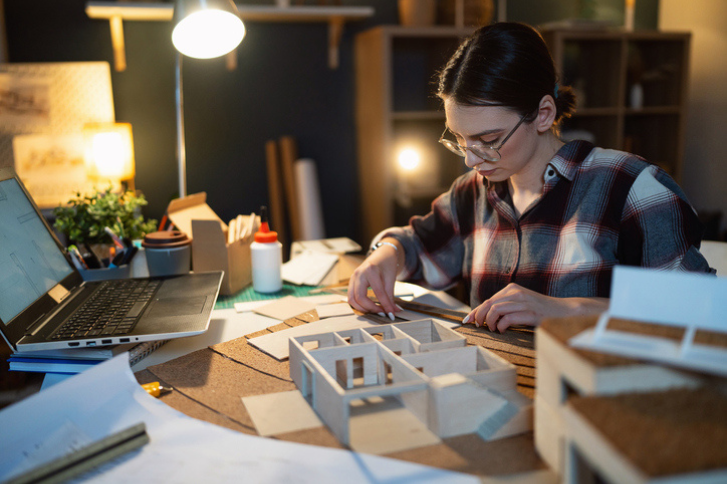 Female architect making an architectural model in her home office