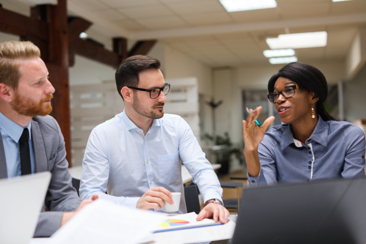 Coworkers discussing strategy during business meeting