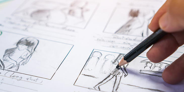 a hand drawing a storyboard in pencil